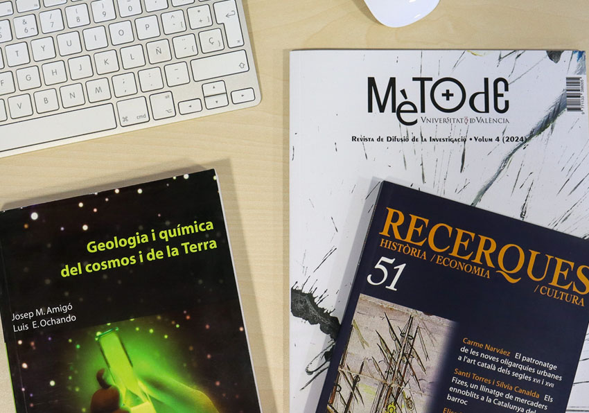 event image:Books, magazines and other academic publications on a table next to a keyboard and a mouse.