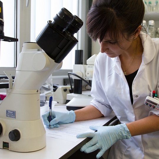 Una estudiante con un microscopio.