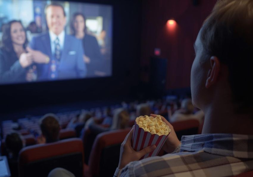 Imagen del evento:Hombre en el cine comiendo palomitas y viendo una película en la pantalla